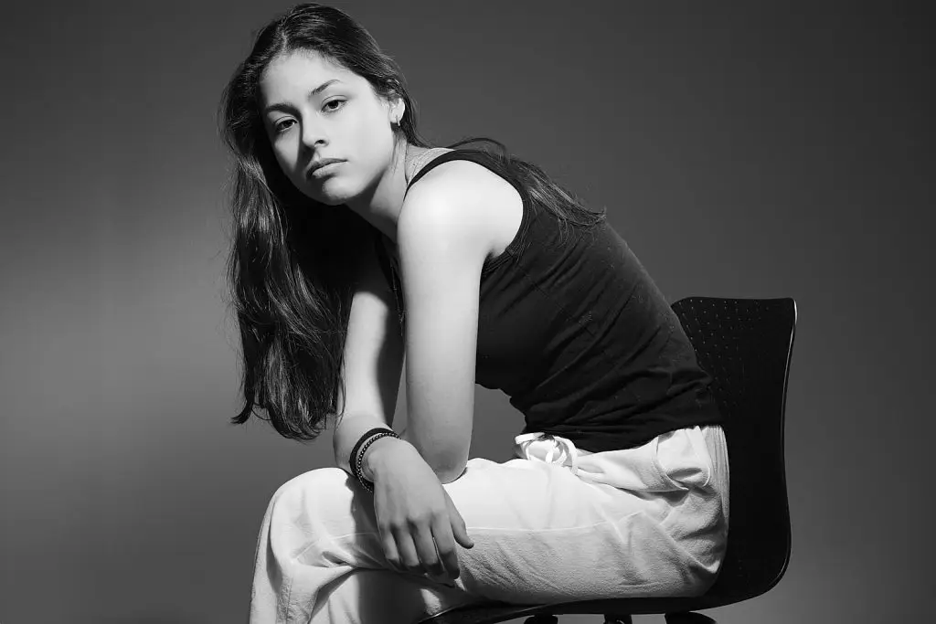 Portrait d'une jeune femme en noir et blanc. Pose assise. Lumière dure et contrastée. Réalisé par le Studio Tajan à Tarbes.