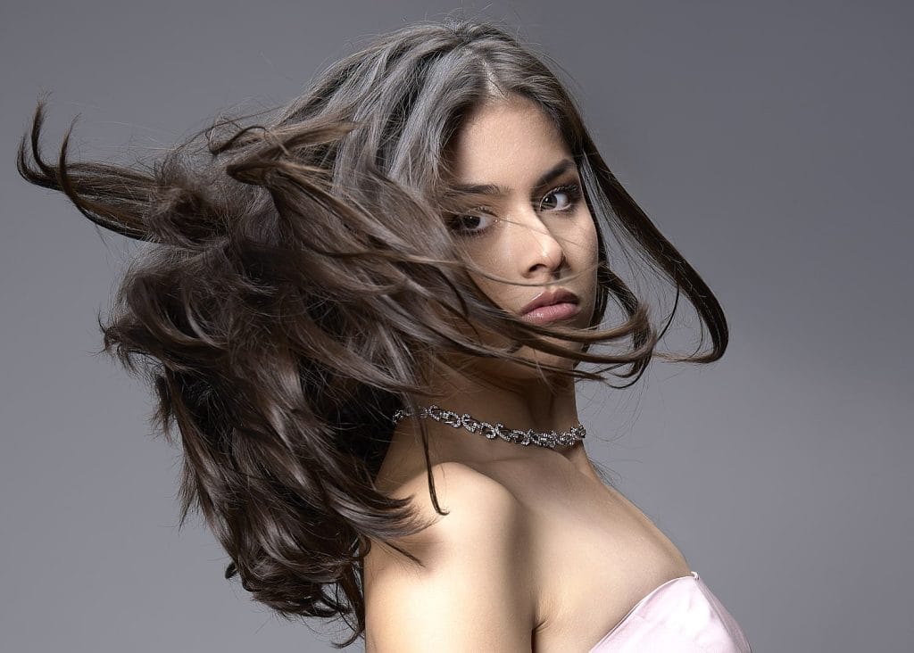 Portrait artistique en couleur et en mouvement d'une jeune fille. Plan poitrine. Lumière douce et contrastée. Réalisé en studio à Tarbes.