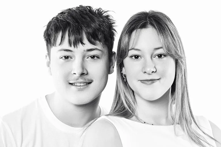 Portrait de famille-frêre et soeur. Plan épaule. Ambiance hight key. Visages souriants et fond blanc.