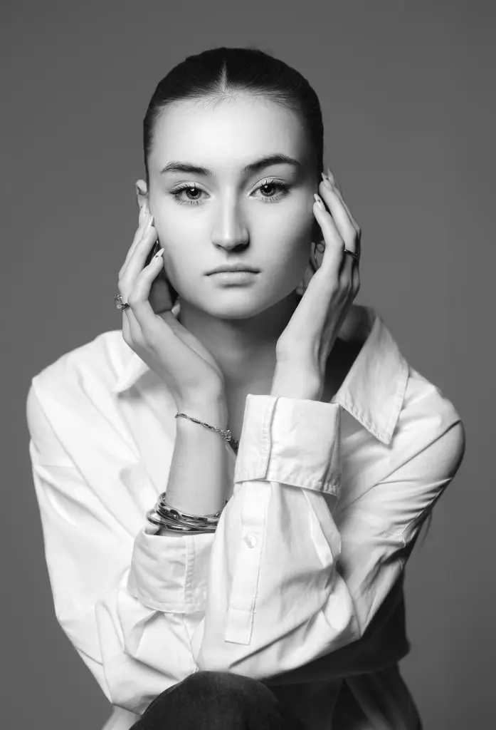 Portrait artistique en noir et blanc d’une jeune femme en studio à Tarbes (65), pose stylisée et lumière douce, réalisé par Studio TAJAN.