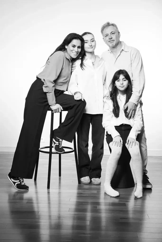 photo de famille réalisée en studio mettant en lumière un couple avec deux enfants. Dynamique de l'image due à une composition de poses assises et debout.