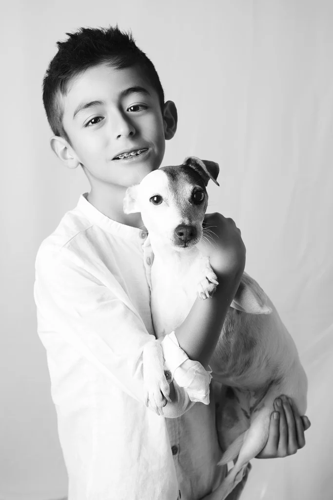 Portrait d'un garçon avec son chien. Photo en noir et blanc réalisé dans notre studio professionnel sur Tarbes.