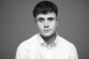 Portrait lumineux d'un jeune homme fait dans notre studio photo professionnel. Plan épaule, visage de face, lumière type butterfly.