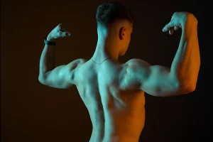 portrait d'un homme vue de dos. Ambiance salle de musculation en studio sur Tarbes.