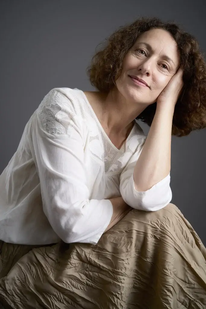 Portrait couleur au féminin. Belle attitude souriante, pose assise. Photo prise par le studio tajan à Tarbes.