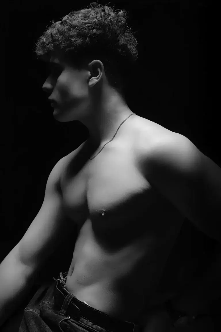 Portrait fitness de profil, épaule et pectoral sculptés par l’ombre