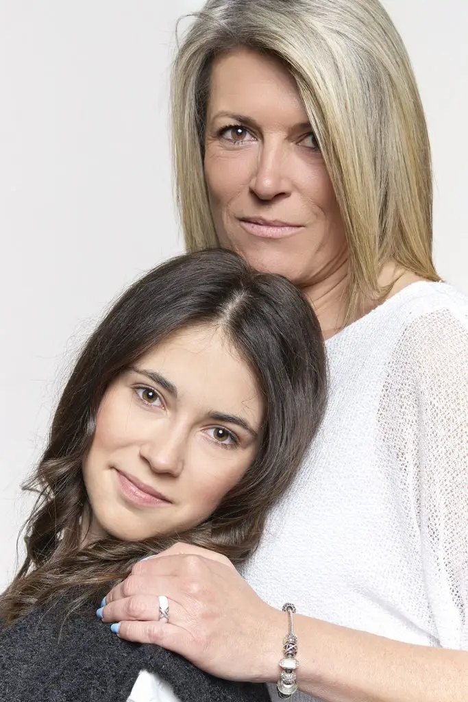 Photo en couleur d'une mère et de sa fille réalisé en lumière douce et sur fond blanc par le studio Tajan, photographes sur Tarbes.