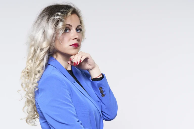 Belle photo de Béa, une jeune modele qui pose avec une veste bleu de la même couleur que ses yeux.