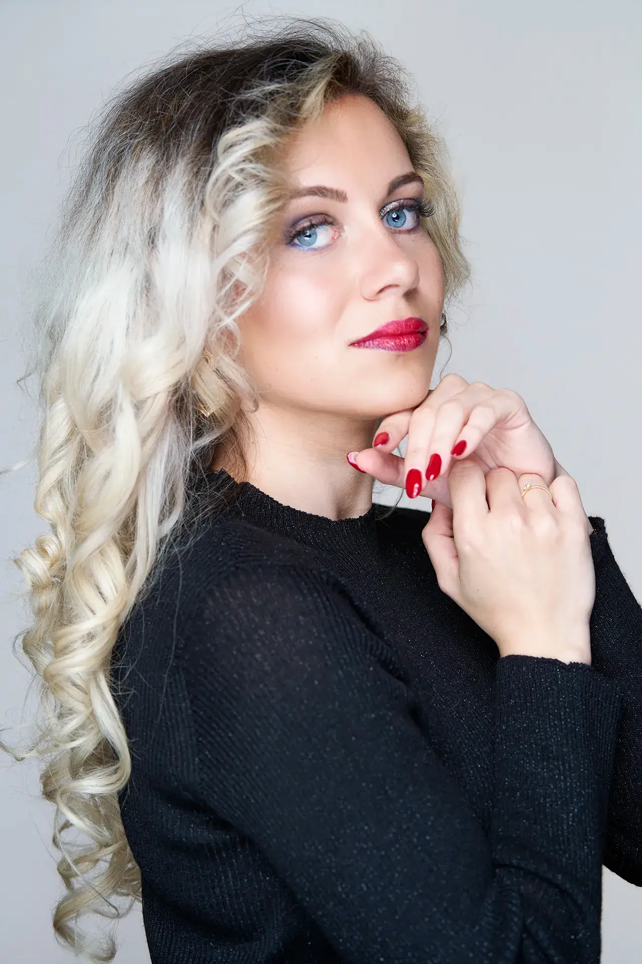 portrait en couleur d'une jeune femme habillée en noir. Style beauté mettant en valeur ses yeux bleus.