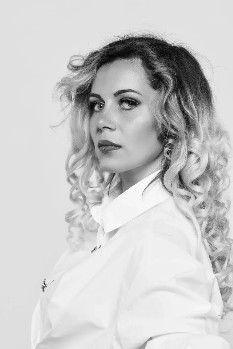 portrait beauté high key en noir et blanc. Jeune femme bonde plan épaule, lumière douce.