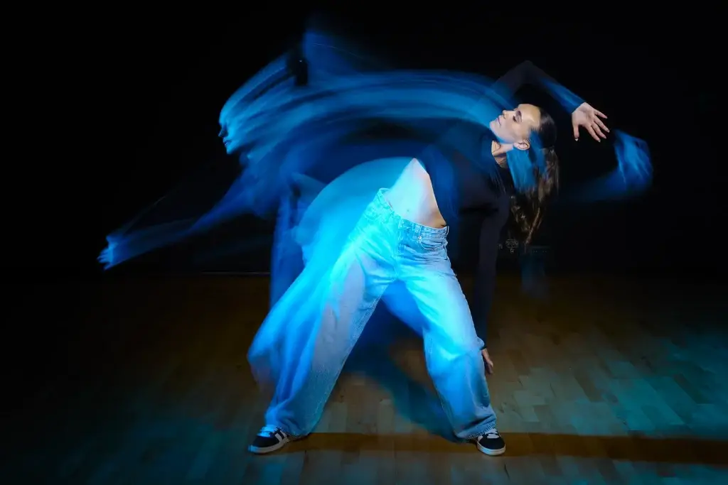 photo d'une danseuse en mouvement avec des trainées lumineuses qui suivent son déplacement.