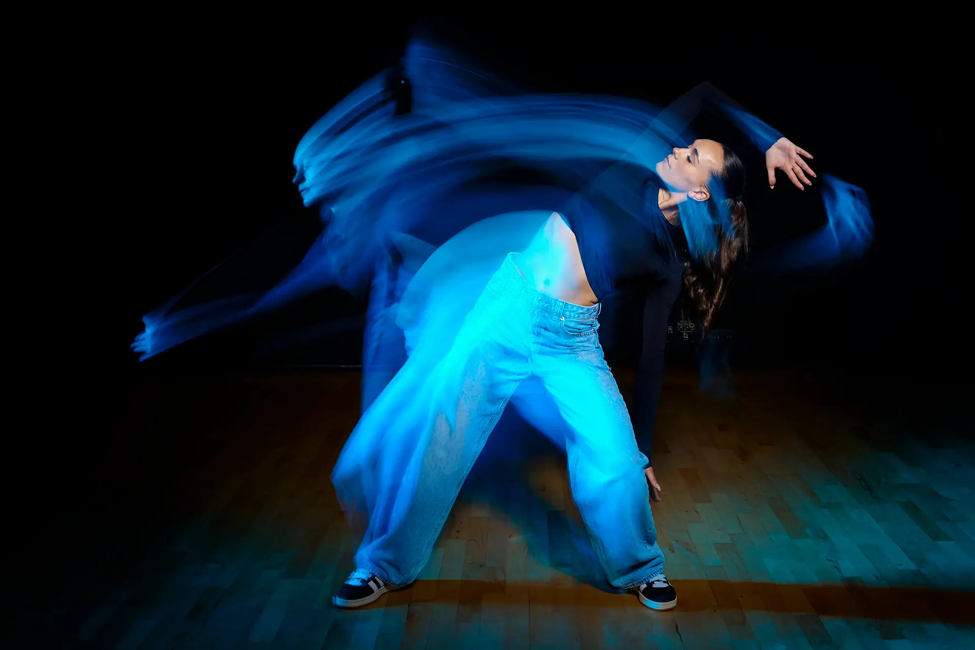 photo d'une danseuse en mouvement avec des trainées lumineuses qui suivent son déplacement.