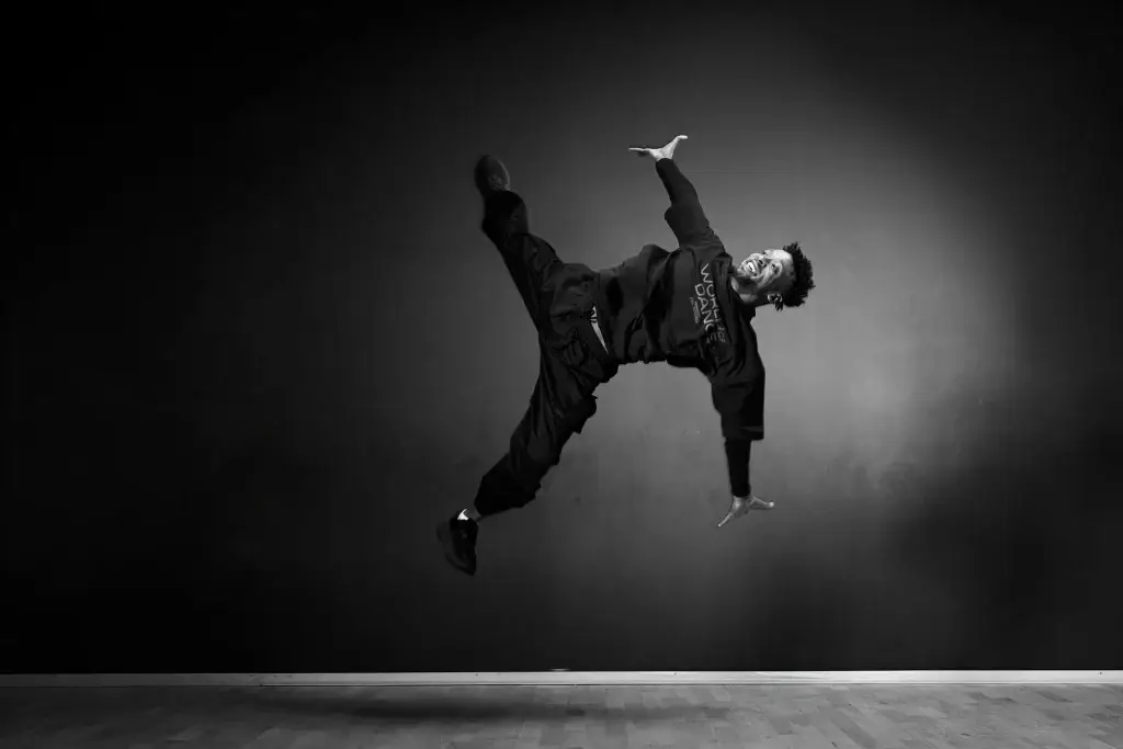 Danseur électro suspendu en l’air, bras et jambes écartés, noir et blanc