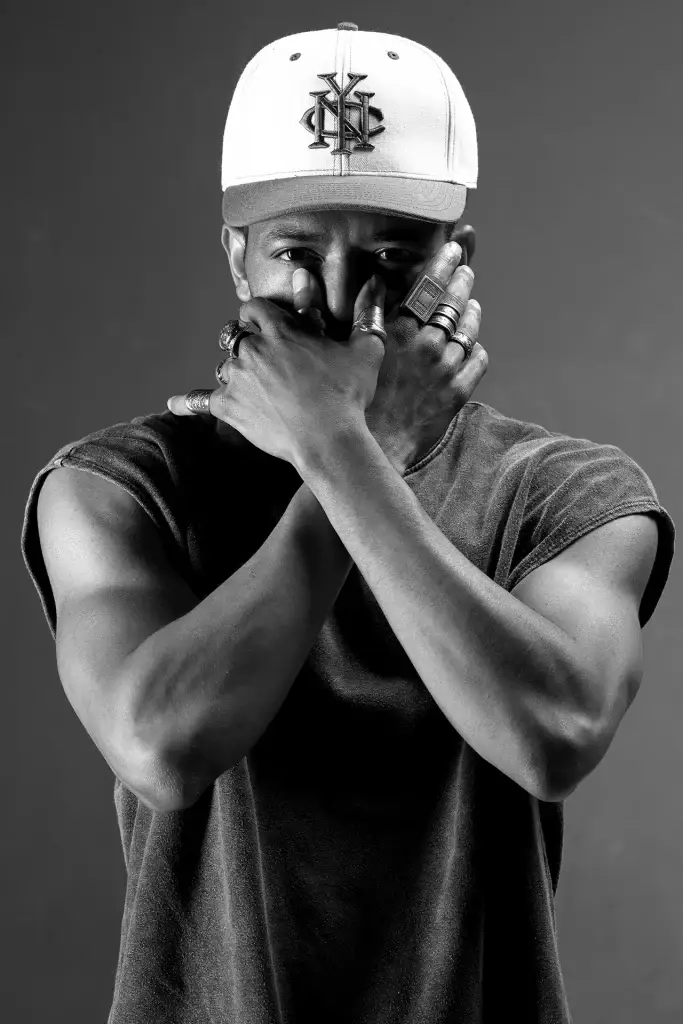Portrait en noir et blanc de Fakri, un danseur de Hip Hop sur Tarbes. Plan taille, lumière contrastée.