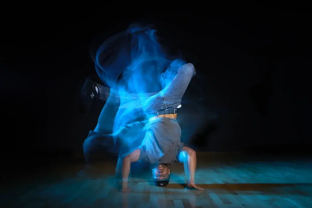 Danseur sur les mains, mouvement révélé par une lumière bleue