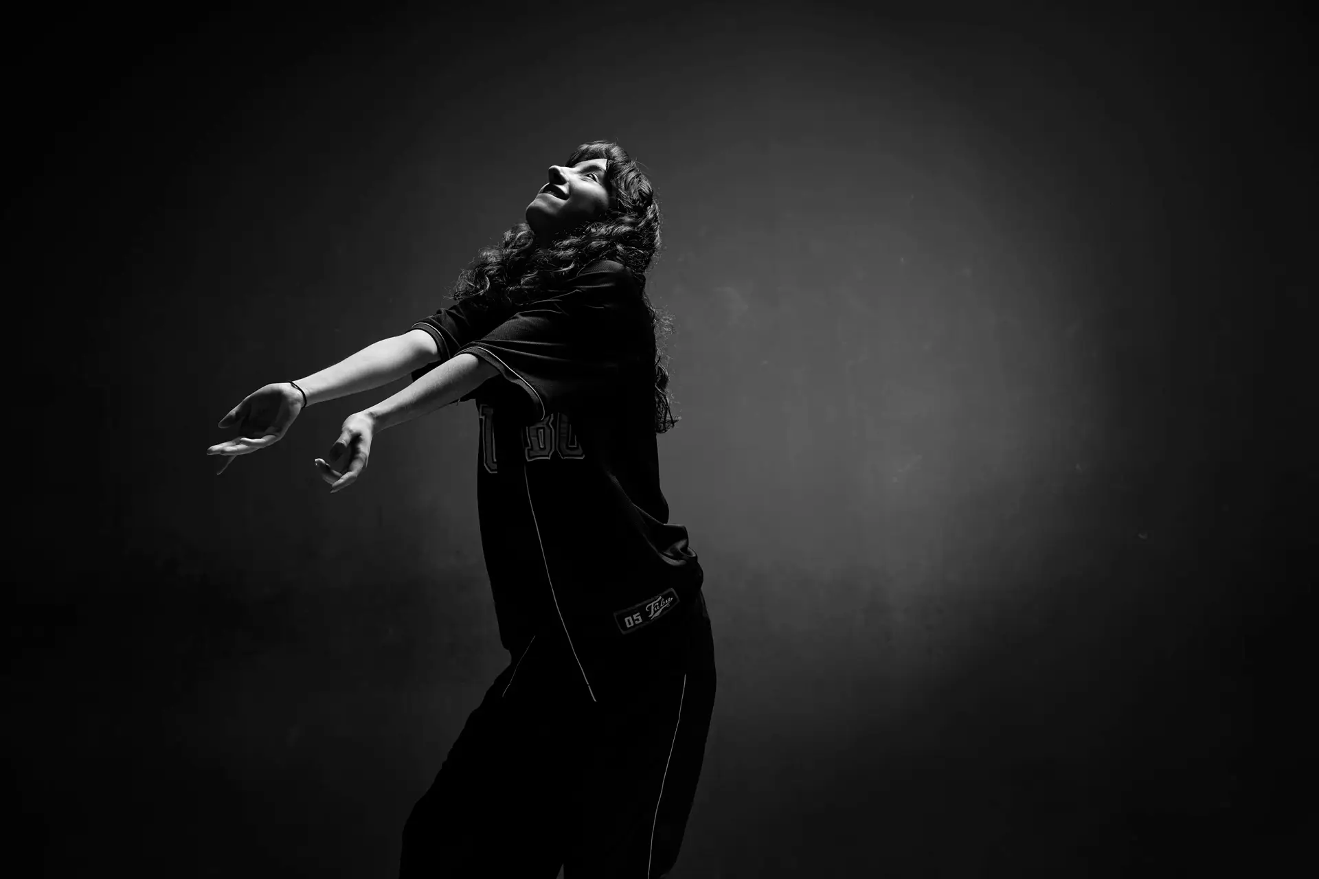 portrait expressif d'une danseuse de hip hop à Tarbes en noir et blanc. La très belle lumière en douche met en valeur soin attitude et son mouvement.