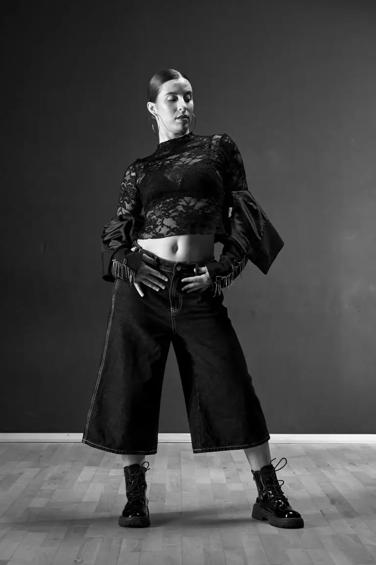 Danseuse hip-hop en pantalon large, mains sur les hanches, noir et blanc