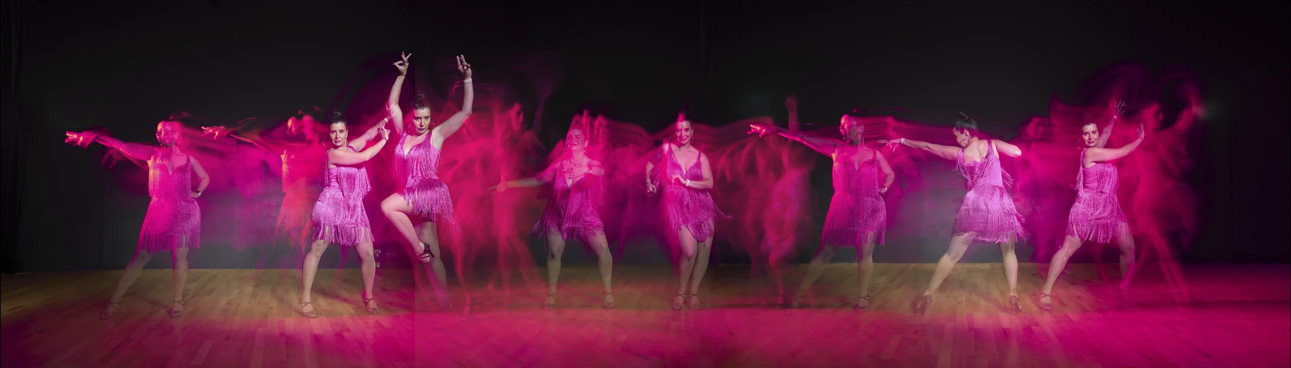 Mise en scène d'ELODIE, une danseuse professionnelle de SALSA de DANS6T, dans une séquence ou chacun de ses mouvements est figé par un éclair de flash lors de son déplacement. La lumière ambiante rose vient jouer avec la couleur rose de sa robe.