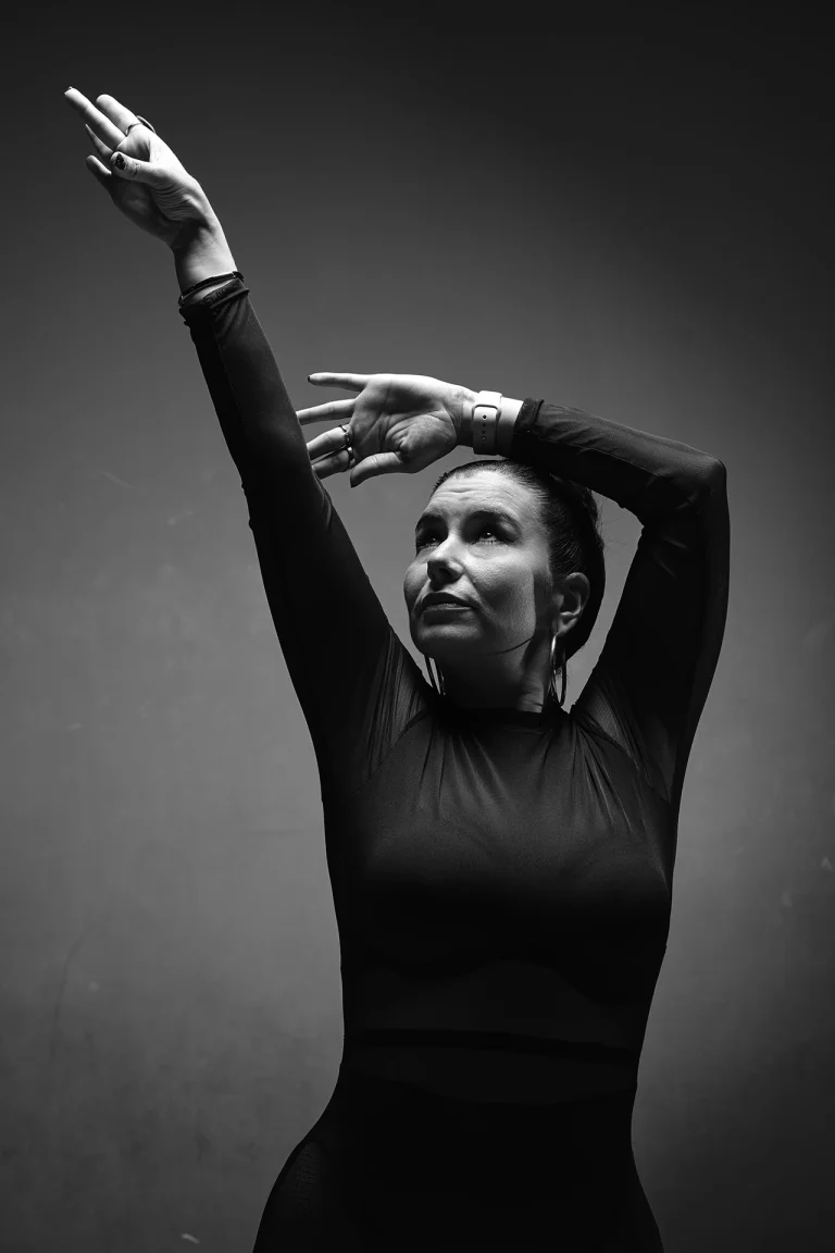Danseuse de salsa, bras levés, portrait en noir et blanc au studio