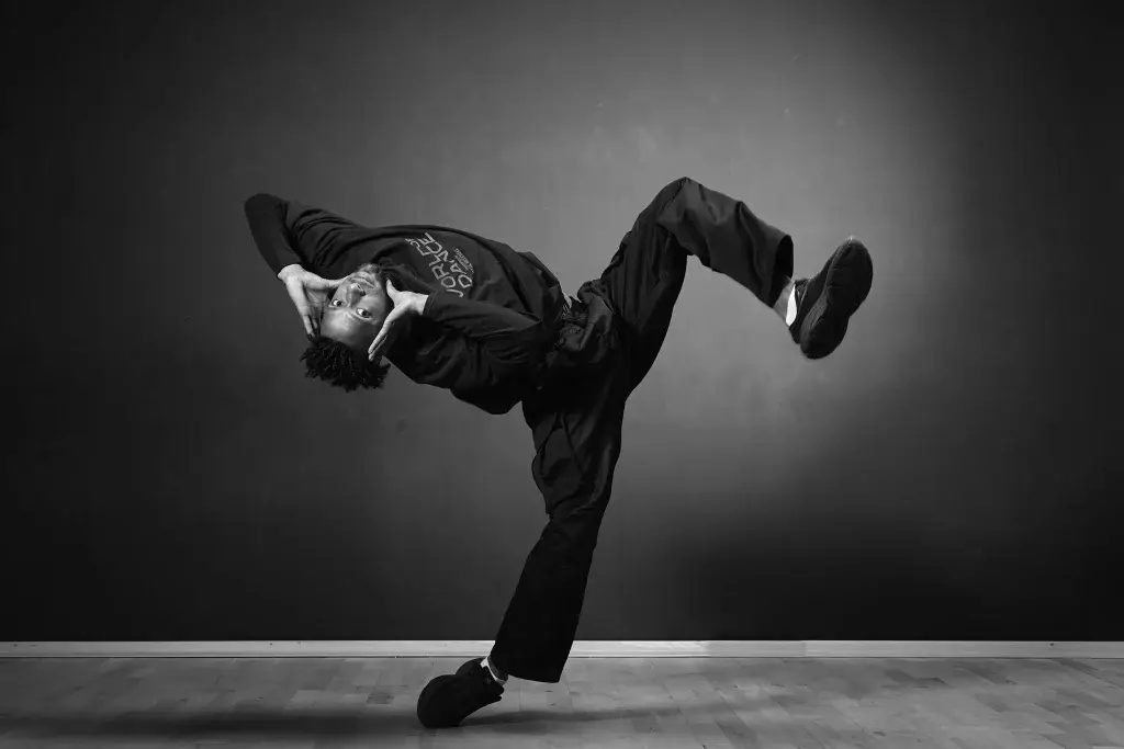 Danseur électro en appui sur une jambe, mouvement figé en noir et blanc