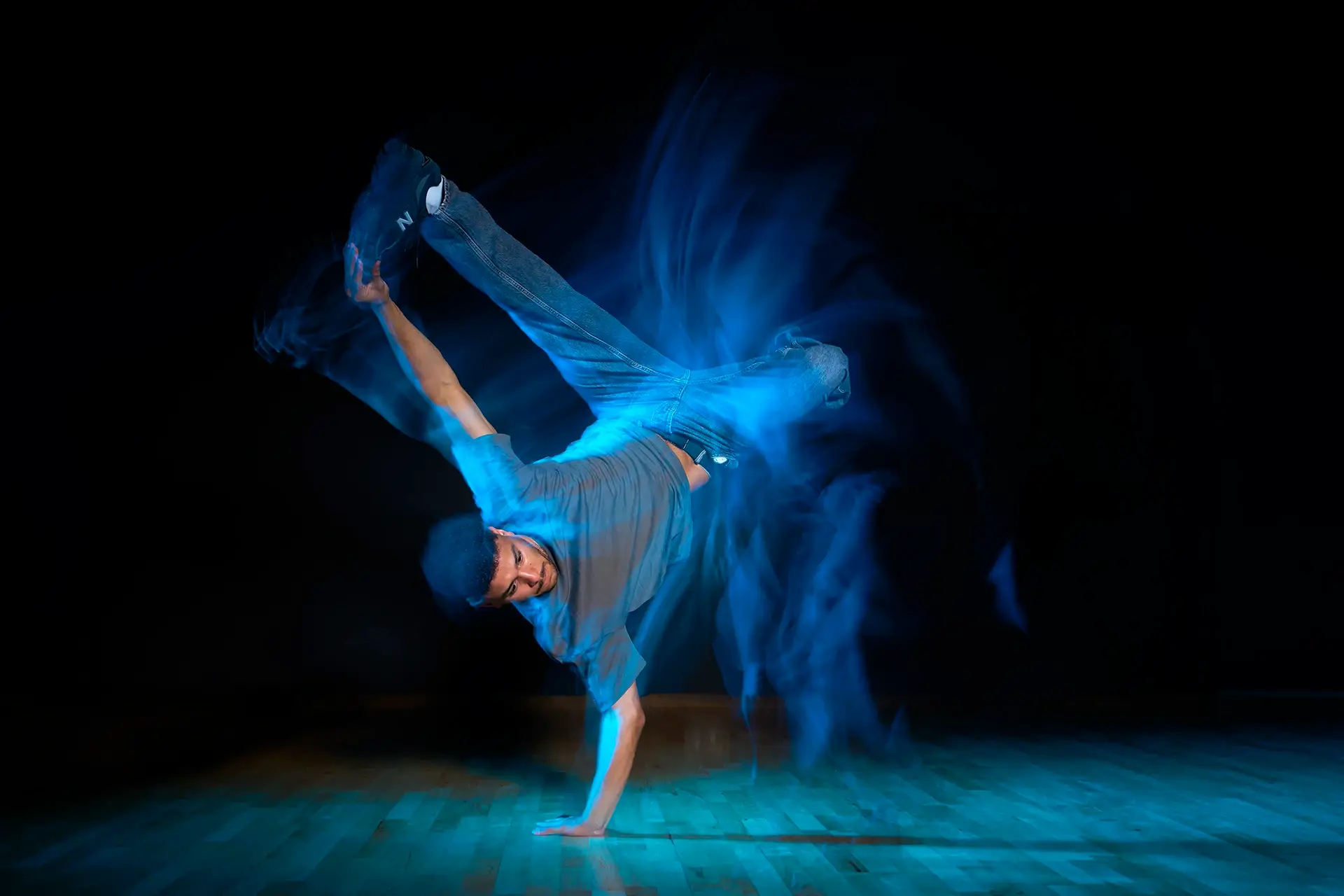 Danseur au sol dans une traînée de lumière bleue, photo de mouvement