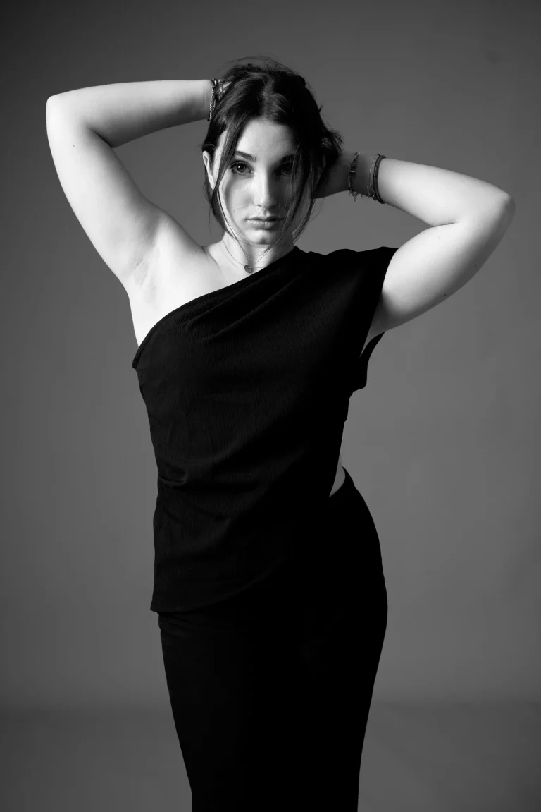 Book modèle en noir et blanc, pose debout, bras levés