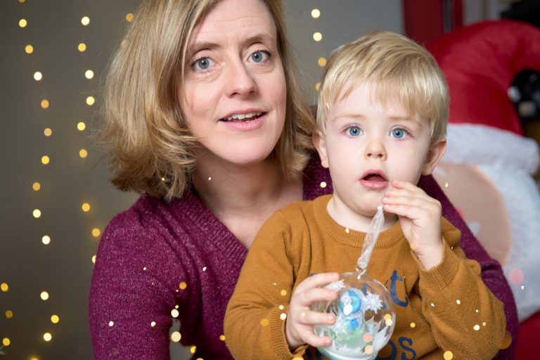 Une maman et son tout-petit dans le décor de Noël