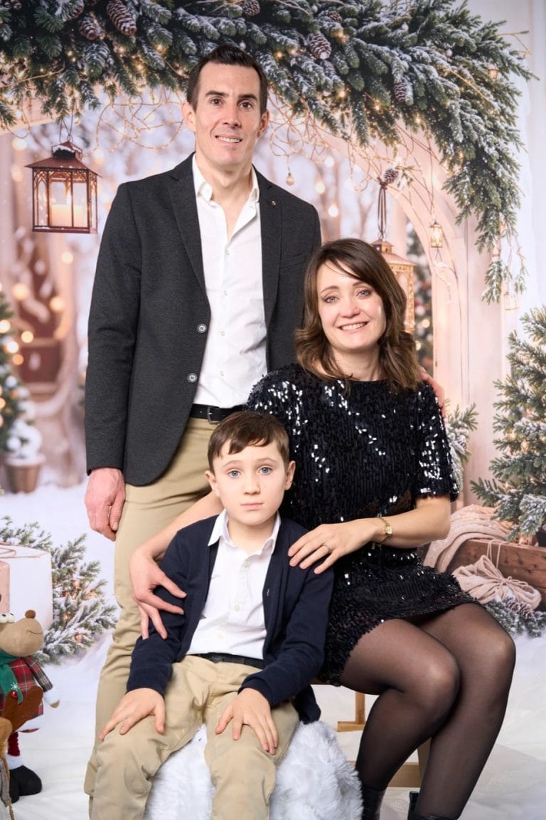 Parents et enfant assis dans le décor de Noël