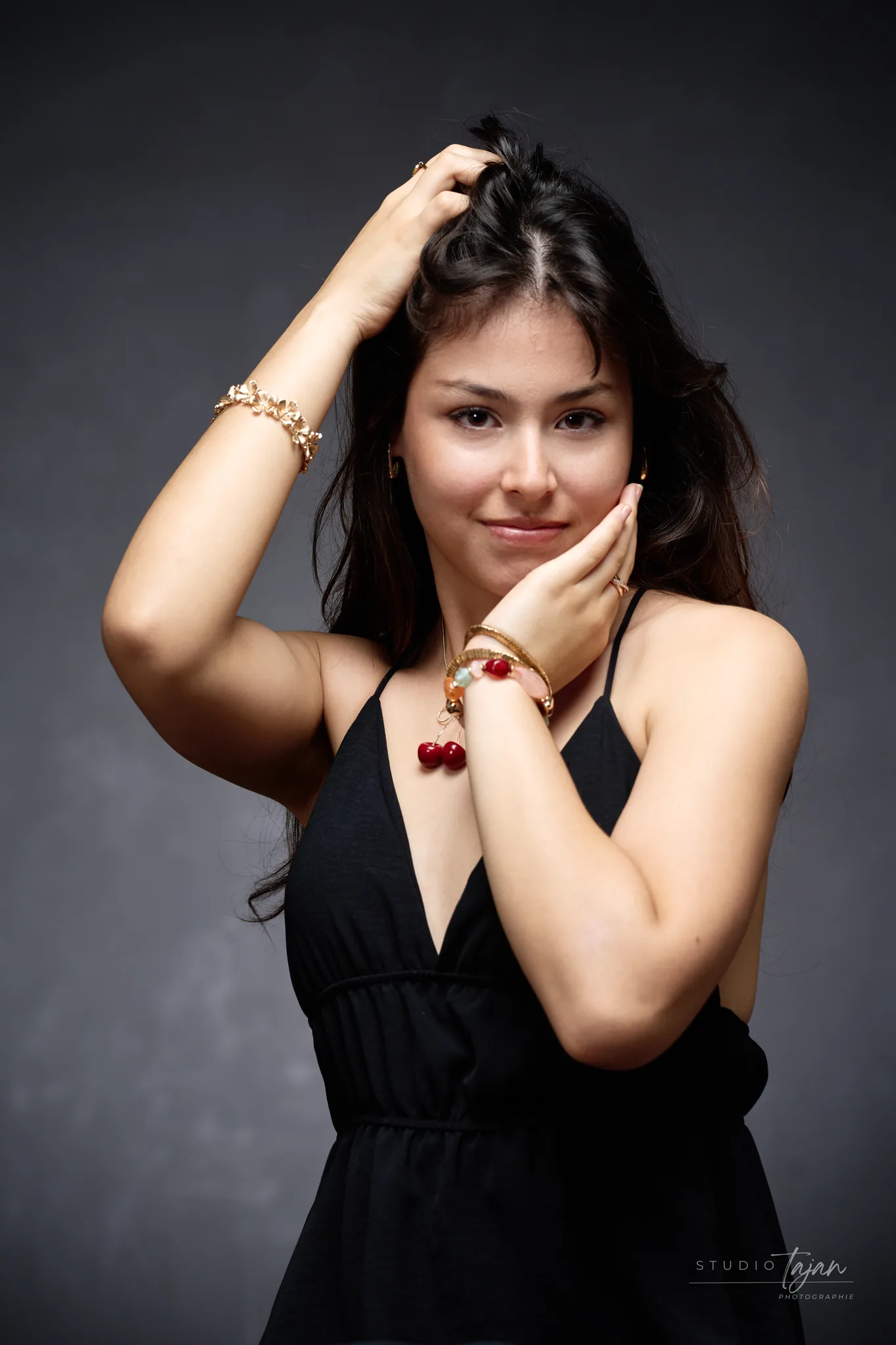 Portrait féminin en couleur, sourire retenu, main sur la joue