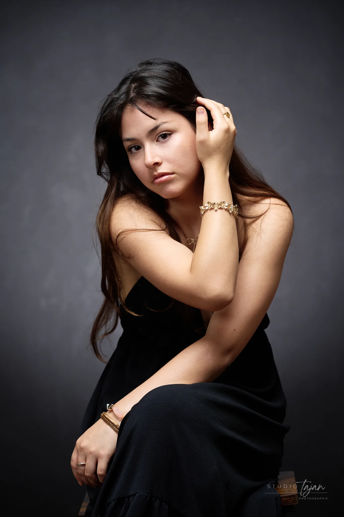 Portrait féminin en couleur, main dans les cheveux, regard vers l’objectif