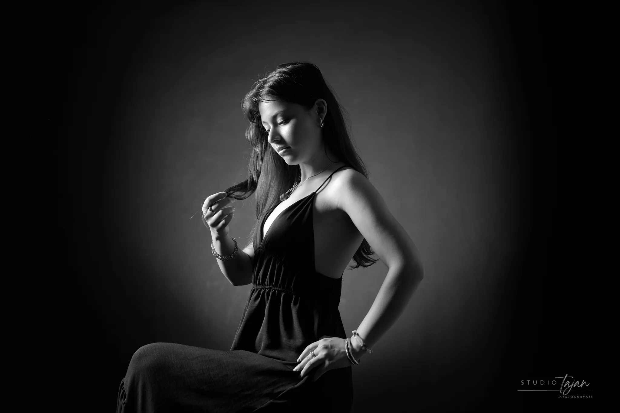 Portrait féminin assis de profil, en noir et blanc